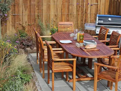 a wooden table and chairs on a patio at Mill House, Boskensoe Barns in Falmouth