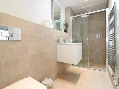 a bathroom with a shower and a toilet and a sink at The Stable, Boskensoe Barns in Falmouth