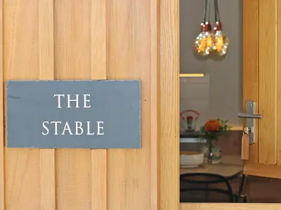 a sign on a door that reads the stable at The Stable, Boskensoe Barns in Falmouth