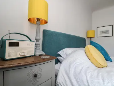 a bedroom with a bed with a radio on a night stand at The Snug in Grampound