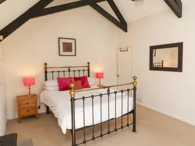a bedroom with a large bed with red pillows at Tower House in Boscastle