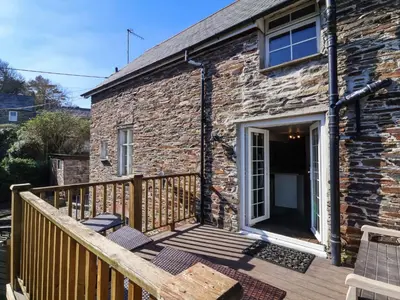 a stone cottage with a wooden deck at Tower House in Boscastle