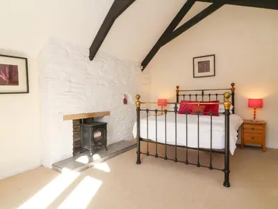 a bedroom with a bed and a fireplace at Tower House in Boscastle