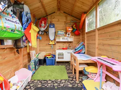 a cabin with a table and a kitchen in it at Daisy Cottage in Perranporth