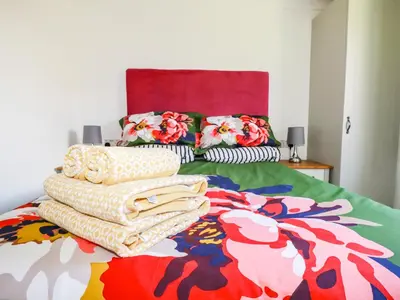 a bed with a colorful blanket and pillows on it at Hunrosa in Redruth