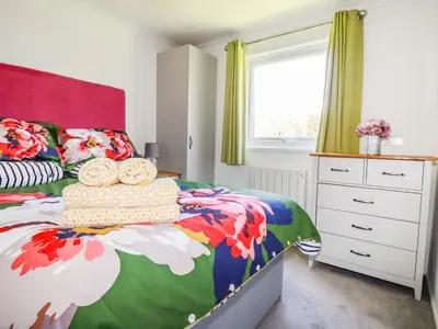a bedroom with a bed with a colorful comforter at Hunrosa in Redruth