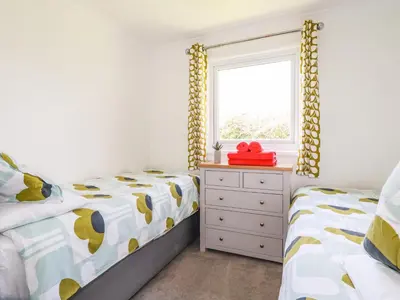 a bedroom with two twin beds and a window at Hunrosa in Redruth