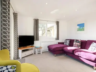 a living room with a purple couch and a tv at Hunrosa in Redruth
