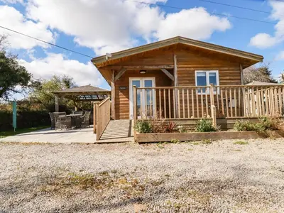 a log cabin with a porch and a deck at Hunrosa in Redruth