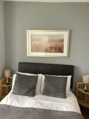 a bed with two pillows and a picture above it at Beechwood House in St Ives