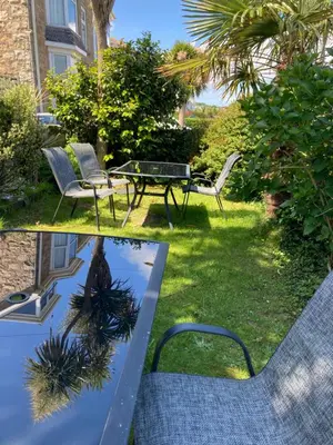 a patio with a table and chairs in a yard at Beechwood House in St Ives