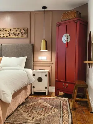 a bedroom with a red cabinet and a bed at Quayside in Mevagissey