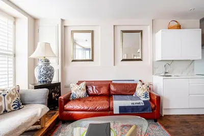 a living room with a leather couch and a table at Quayside in Mevagissey