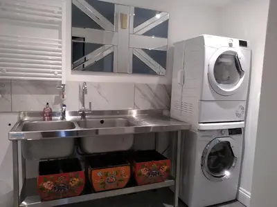a kitchen with a sink and a washing machine at Quayside in Mevagissey