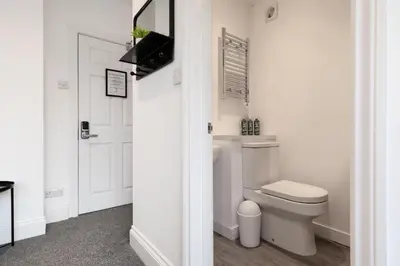 a white bathroom with a toilet and a door at The Nook - Self Serviced Accommodation in St Ives