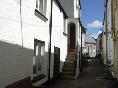 an empty alley with a white building and stairs at Sand Dune in Looe