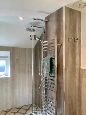 a shower with a glass door in a bathroom at Tresowes Green Cottage in Helston