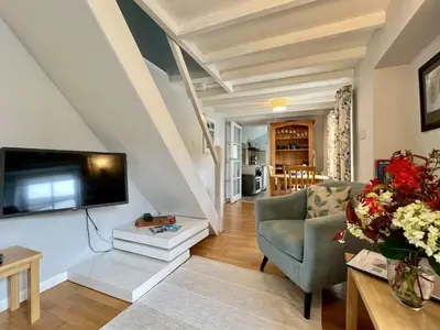 a living room with a couch and a tv at Tresowes Green Cottage in Helston