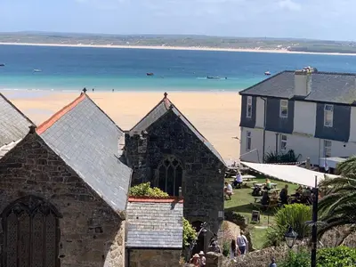 a church and a building with a beach in the background at The Loft in St Ives