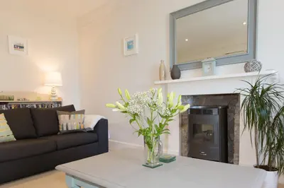 a living room with a couch and a fireplace at The Loft in St Ives