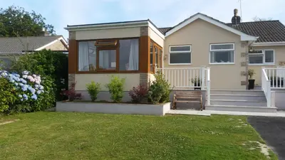 a small house with a lawn in front of it at Seaclusion in St Austell