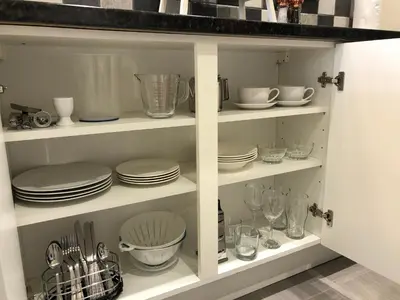 a white cabinet filled with dishes and plates at Seaclusion in St Austell
