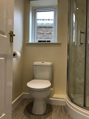 a bathroom with a toilet and a window at Seaclusion in St Austell