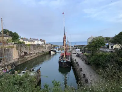 a boat is docked in a canal with other boats at Seaclusion in St Austell