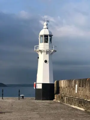 a lighthouse sitting on a pier next to the water at Seaclusion in St Austell