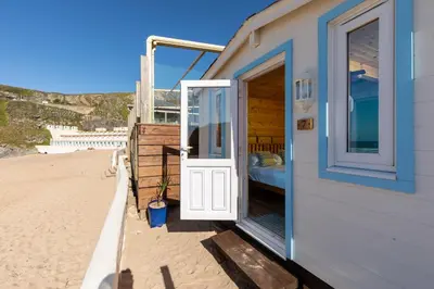 a door to a beach house on the beach at Tolcarne Beach Colonial Restaurant and Rooms in Newquay