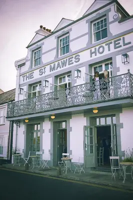 a white building with people on a balcony at St Mawes Hotel in Saint Mawes
