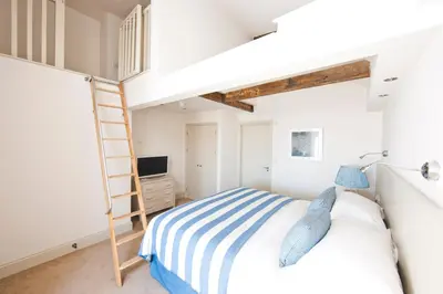 a bedroom with a bunk bed and a ladder at St Mawes Hotel in Saint Mawes