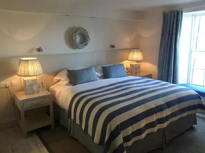 a bedroom with a bed with blue and white stripes at St Mawes Hotel in Saint Mawes