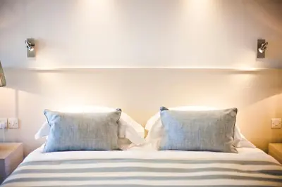 a bed with blue and white pillows in a bedroom at St Mawes Hotel in Saint Mawes