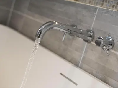 a chrome bathroom faucet with water coming out of it at chyreen@marazion in Marazion