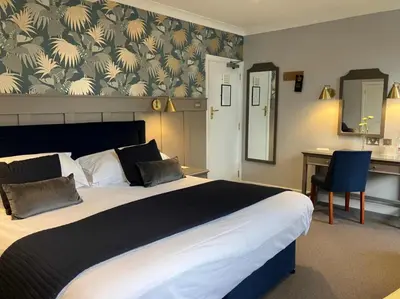 a hotel room with a large bed and a desk at Budock Vean Hotel and Spa in Falmouth