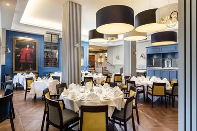 a dining room with tables and chairs with white tablecloths at Budock Vean Hotel and Spa in Falmouth