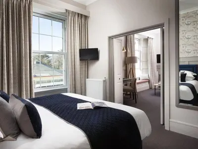 a hotel room with a bed and a large window at Budock Vean Hotel and Spa in Falmouth