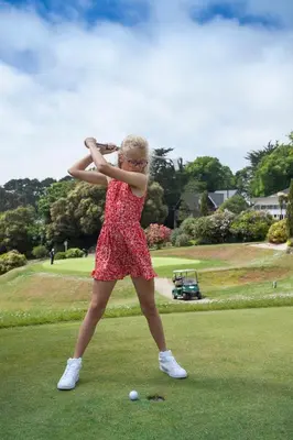 a young girl in a dress standing on a golf course at Budock Vean Hotel and Spa in Falmouth