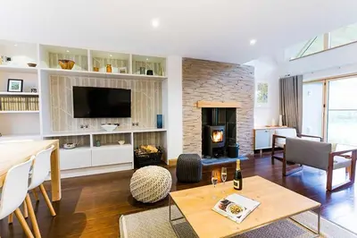 a living room with a table and a fireplace at Budock Vean Hotel and Spa in Falmouth