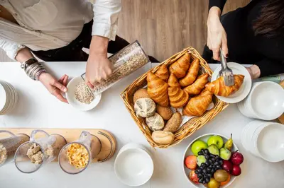 a group of people standing around a table with food at Budock Vean Hotel and Spa in Falmouth