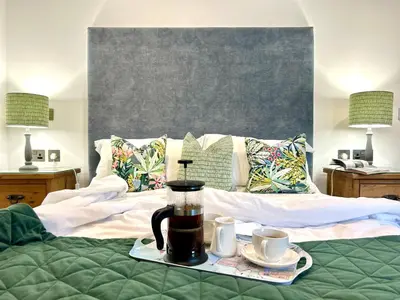 a bed with a coffee maker and two cups on it at Merlin Farm Cottages short walk to Mawgan Porth Beach and central location in Cornwall in Mawgan Porth