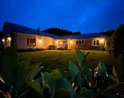 a house at night with lights on it at Merlin Farm Cottages short walk to Mawgan Porth Beach and central location in Cornwall in Mawgan Porth