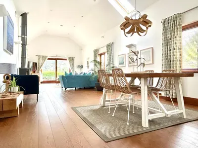 a dining room and living room with a table and chairs at Merlin Farm Cottages short walk to Mawgan Porth Beach and central location in Cornwall in Mawgan Porth