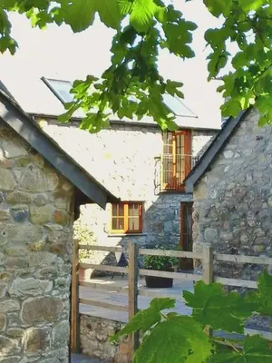 a stone house with a wooden gate and a fence at Tremodrett House Barn in Bodmin