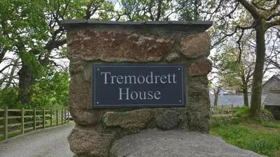 a sign for a terraced house on a stone wall at Tremodrett House Barn in Bodmin