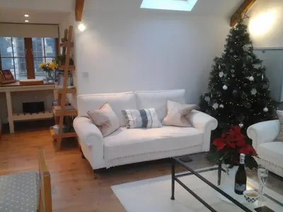 a living room with a christmas tree and a white couch at Tremodrett House Barn in Bodmin