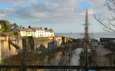 a tall ship is docked next to a wall at Tremodrett House Barn in Bodmin
