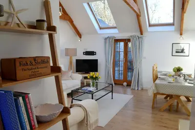 a living room with a white couch and a table at Tremodrett House Barn in Bodmin