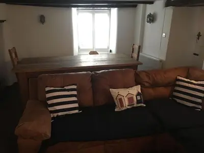 a living room with a brown couch with pillows on it at The Old Vicarage in Looe